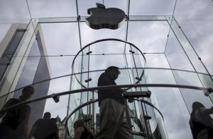 Customers enter the Apple store on 5th Avenue beneath an Apple logo in the Manhattan borough of New York City, July 21, 2015. REUTERS/Mike Segar -