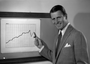 Portrait of cheerful businessman showing chart
